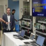 Attendees engage with cybersecurity demonstration equipment at the 8th Annual UNCW Cybersecurity Conference.